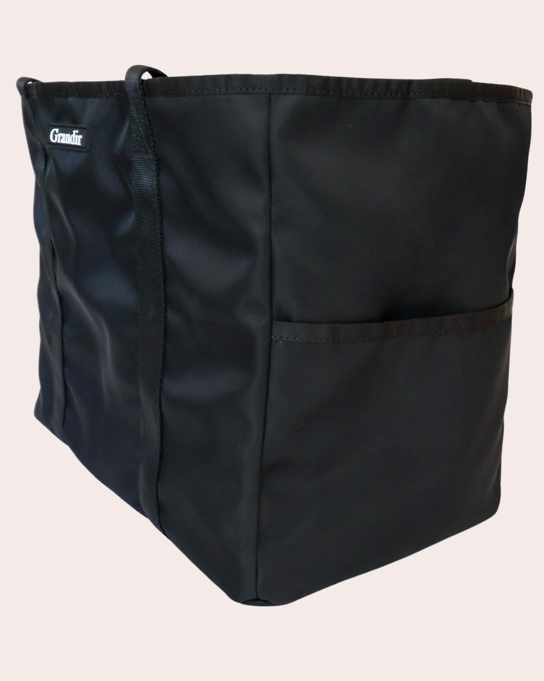 Black tote bag with a visible brand logo on a white background